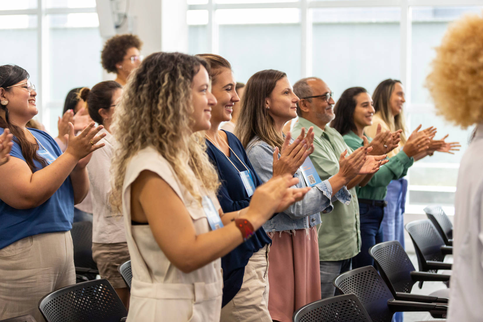 People of various ethnicities giving a standing ovation business lecture