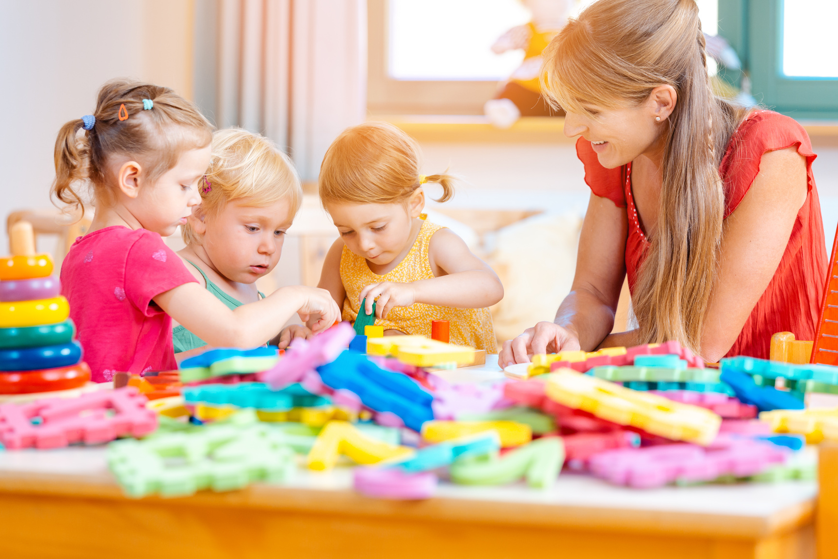 Group of Children and Teacher Playing in Kindergarten